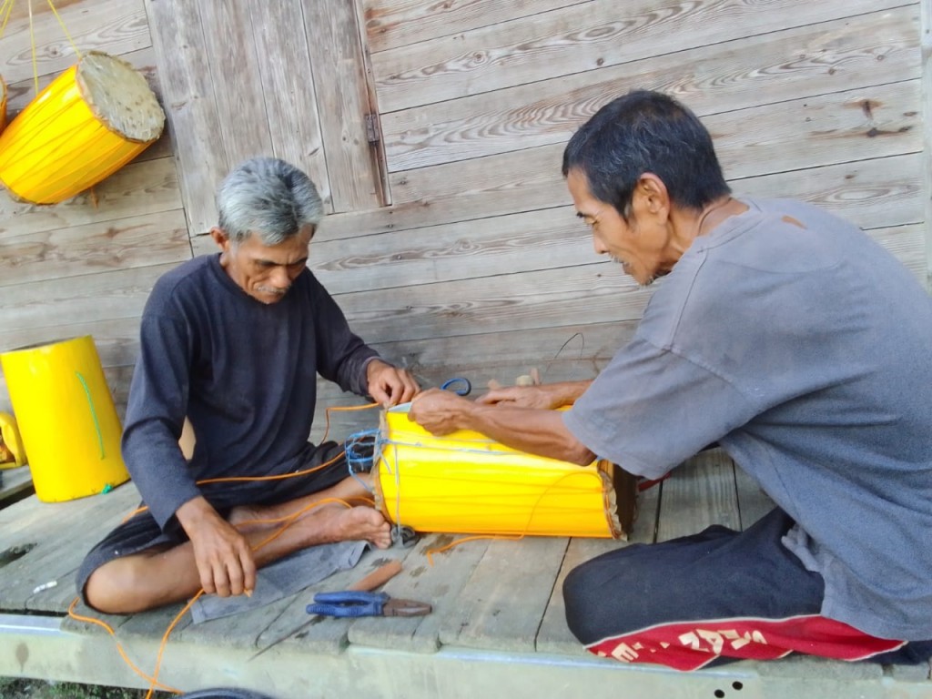 Dua Warga Simpang Abail Sedang Merakit Alat Musik Tradisional Berbahan Kulit Pohon Nangka, Dengan Pe